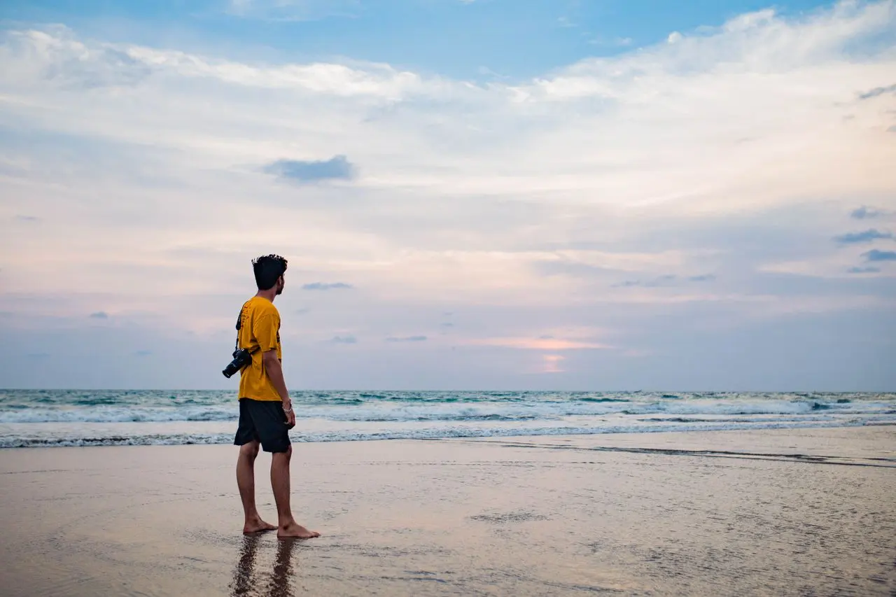 A visitor photographing a Goa sunset